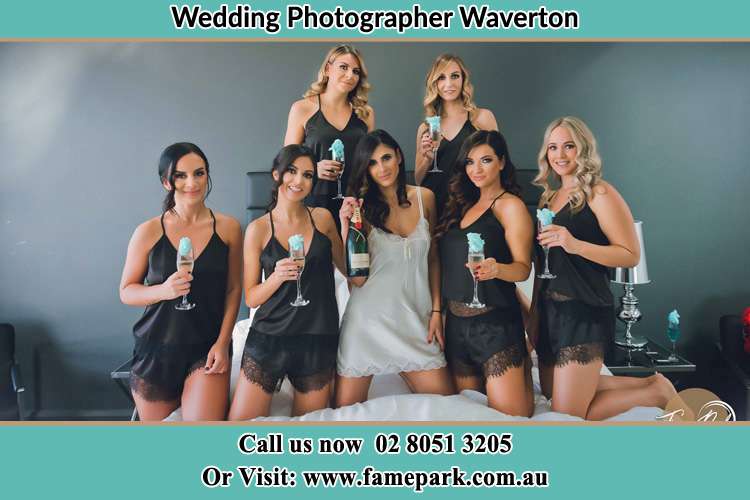 Photo of the Bride and the bridesmaids wearing lingerie and holding glass of wine on bed Waverton NSW 2060